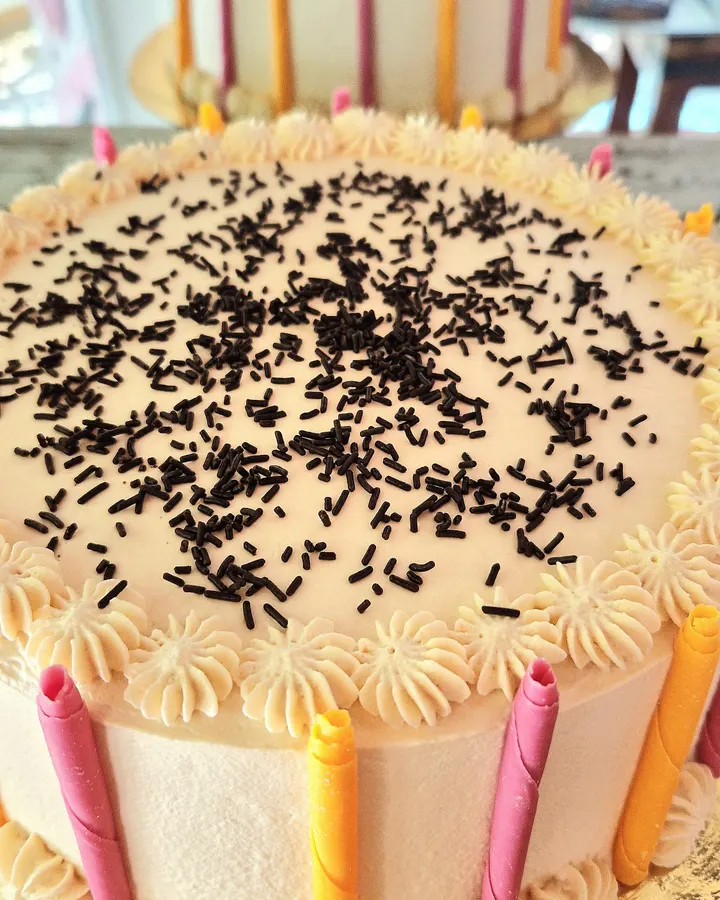 Tarta de cumpleaños con velas de colores y fideos de chocolate